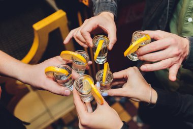Eski bir ahşap masa siyah arka plan üzerinde gözlük ile toasting arkadaşlar vurdu.