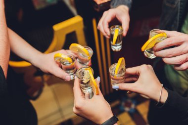Eski bir ahşap masa siyah arka plan üzerinde gözlük ile toasting arkadaşlar vurdu.