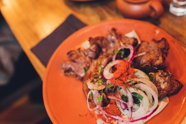 Pork kebabs with onion, bbq meat on plate, top view.