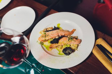Grilled salmon fish with fresh vegetables on plate.