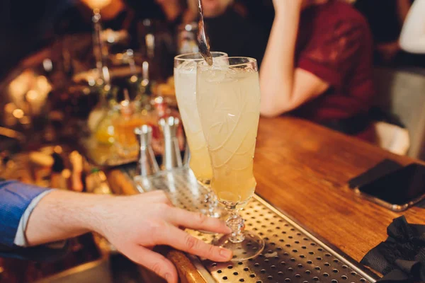 BarTender att göra en cocktail med hjälp av bar utrustning ordnade på bar counter. — Stockfoto