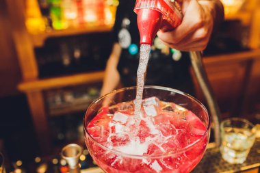 bartender prepares a great cocktail close-up on the background of the bar.