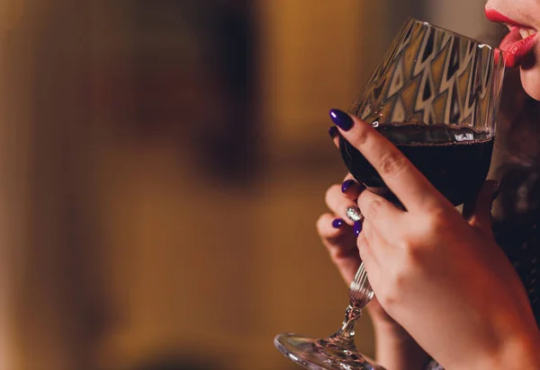 Beautiful woman in a black dress with a glass in hand. — Stock Photo, Image