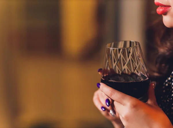 Beautiful woman in a black dress with a glass in hand. — Stock Photo, Image