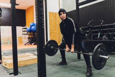 Spor salonunda egzersiz yapan Müslüman Asyalı kadın..