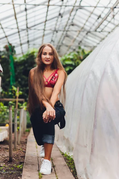 Pretty young woman gardening in an apron, without clothes. — ストック写真