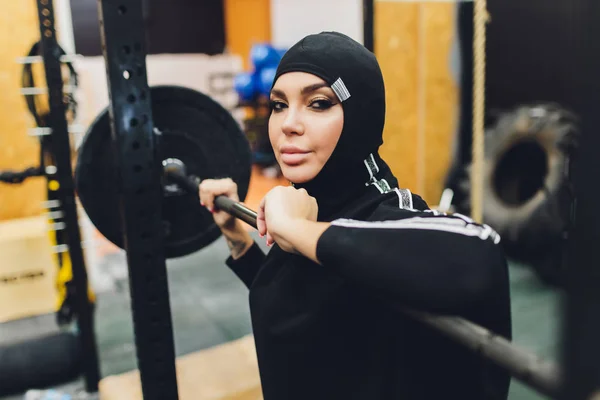 Musulmán asiático mujer en hijab ejercitando en un gimnasio . — Foto de Stock