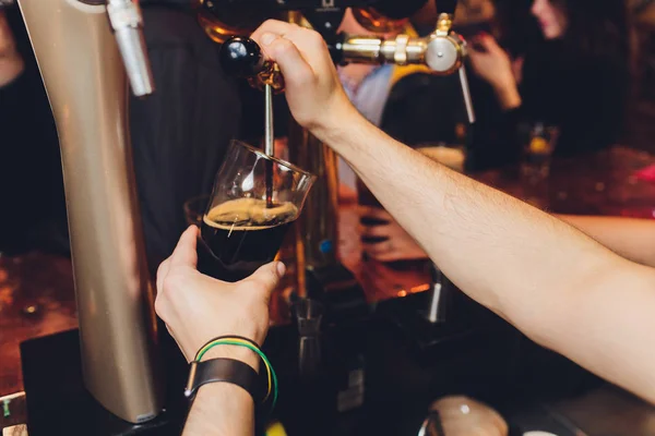 Κοντινό πλάνο μπάρμαν αρσενικό Δοσομέτρηση βαρελίσια μπύρα σε μία παμπ κρατώντας ένα μεγάλο ποτήρι ποτήρι με λαβή με ένα συνημμένο τάπα για ένα βαρέλι από ανοξείδωτο χάλυβα. — Φωτογραφία Αρχείου