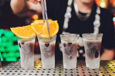 Barmen güçlü alkollü içecek bar, çekim küçük gözlük içine dökme.