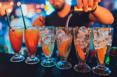 Kokteyl Çubuğu'nda bizi bekleyen bir cam içine dökülen barmen yapar.