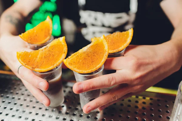 Бармен наливає міцний алкогольний напій у невеликі келихи на барі, постріли . — стокове фото