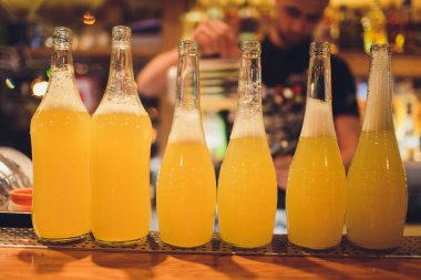 Bardaki ahşap masada altı şişe taze limonata..