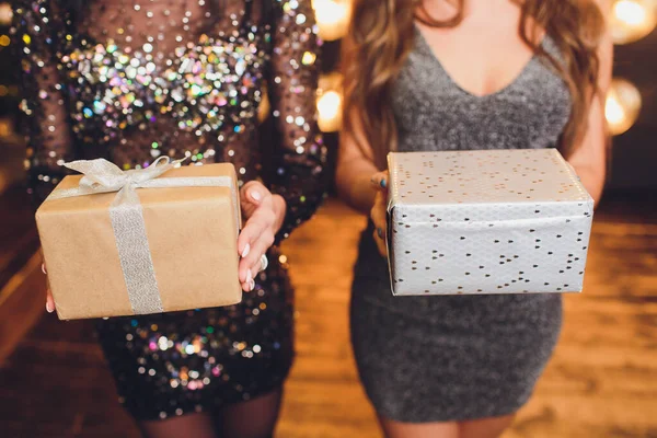 Close up shot of female hands holding a small gift wrapped with pink ribbon. Small gift in the hands of a woman indoor. Shallow depth of field with focus on the little box. — Stock Photo, Image