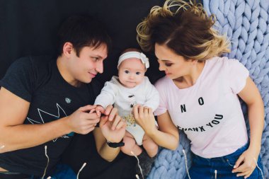 Parents cuddling baby in bed at home. Mom, dad and baby. Happy family concept.