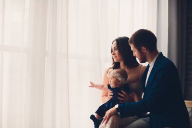 young beautiful happy family in elegant clothes with little smiling child.