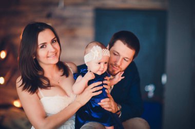 young beautiful happy family in elegant clothes with little smiling child.