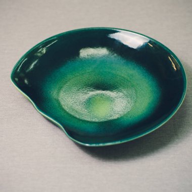 Dalgalı kenarı olan boş mavi plaka, kırpma yolu olan beyaz arkaplanda izole edilmiş dalgalı desenli döşeme, yan görüş.