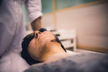 Siyah maskeli kadın prosedür karbon lazer soyarak.