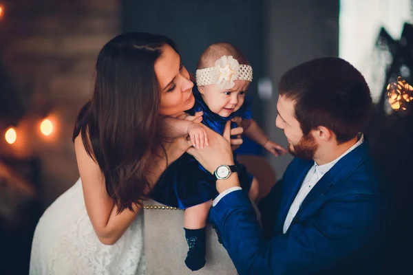 Молода красива щаслива сім'я в елегантному одязі з маленькою усміхненою дитиною . — стокове фото