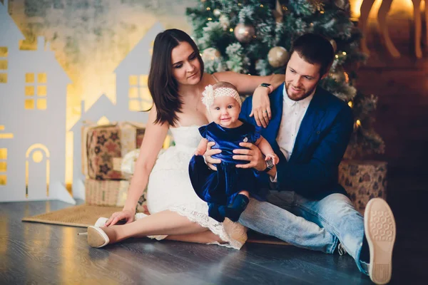 Papa, mama en dochter bij de kerstboom. — Stockfoto