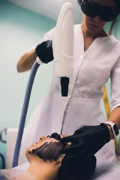 Mulher em máscara preta no procedimento de descascamento a laser de carbono . — Fotografia de Stock