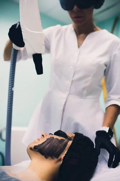 Mulher em máscara preta no procedimento de descascamento a laser de carbono . — Fotografia de Stock