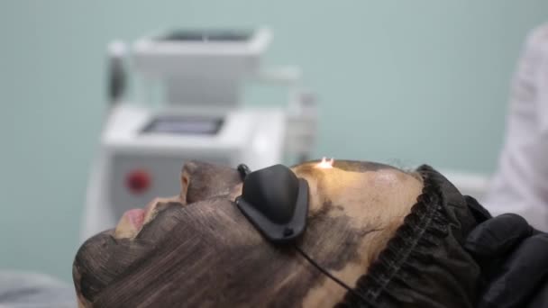 Kvinna i svart mask på förfarande kol laser peeling. — Stockvideo