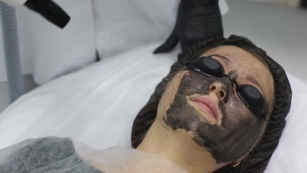 Woman in black mask on procedure carbon laser peeling. — Stock Video