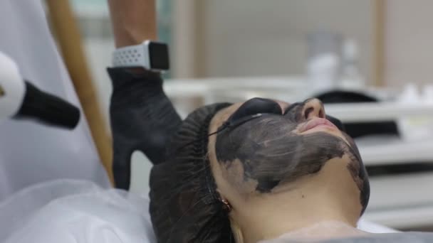 Kobieta w czarnej masce na zabieg łuszczenia laserowego węgla. — Wideo stockowe