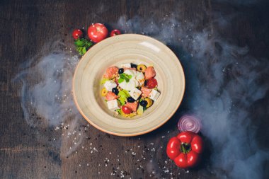 Zeytinli Akdeniz salatası ve kırsal ahşap masada beyaz peynir. Üst görünüm.