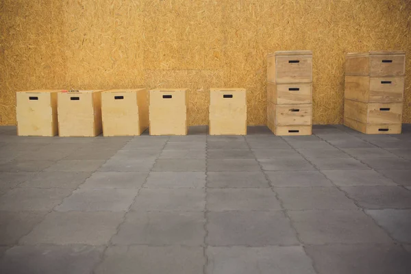 Concept sportif, personne. Boîte en bois pour les sauts de cross training debout au centre de la salle de gym. Équipement de sport, intérieur, intérieur . — Photo