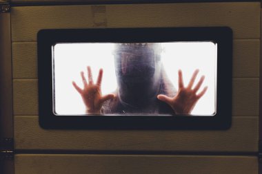 Coronavirus covid-19 karantina ve hastanedeki karantina odasının penceresinde hastalık kontrol uzmanları Coronavirus enfeksiyonlu hastasına hastalık tedavisi uyguluyorlar..