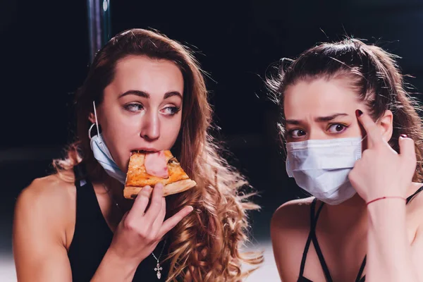 Alerjim var. Tıbbi maske. Pizza yiyen genç bir kadın. — Stok fotoğraf