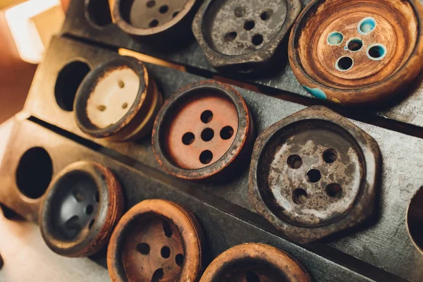 Narghilè e quattro diverse ciotole di narghilè sul tavolo primo piano su uno sfondo blu scuro girato in stile low key . — Foto Stock