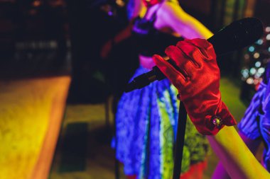 renkli arka planı tek bir retro mikrofon tutan el.