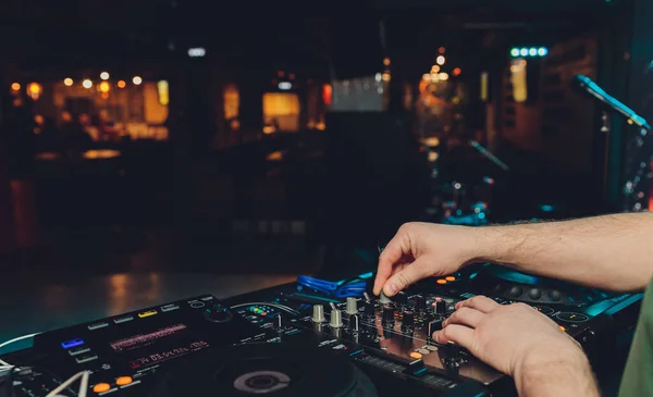DJ mesa giratoria mezclador de consola de control con dos manos en el escenario de discoteca concierto . — Foto de Stock