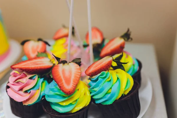 Coloridos cupcakes de cumpleaños en la mesa de madera blanca, la puesta plana . —  Fotos de Stock