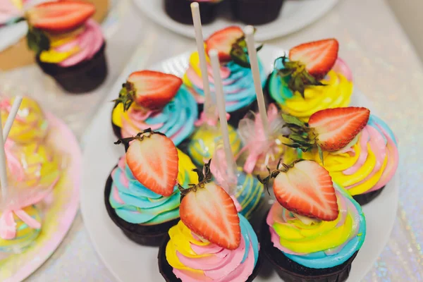 Cupcakes d'anniversaire colorés sur table en bois blanc, plat laïc . — Photo