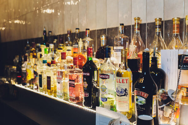 Ufa, Russia, 1 January, 2020: Several types of bottled alcohol are displayed on some shelves in a pub.
