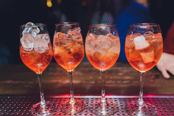 Cocktail alcolico tonico Campari con amaro rosso, tonico, lime e ghiaccio. Vecchio sfondo tavolo in legno, strumenti bar, messa a fuoco selettiva. Tutti i nomi si riferiscono a cocktail, non marchi . — Foto Stock