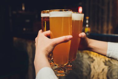 garson bir bar veya barda elinde bira bardak tutar. Bira bardakları.