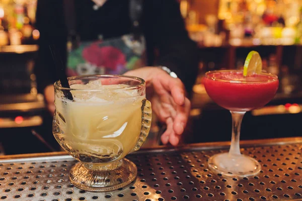 Verse drank cocktails, groene munt en limoen op een kleur achtergrond wazig bokeh. — Stockfoto
