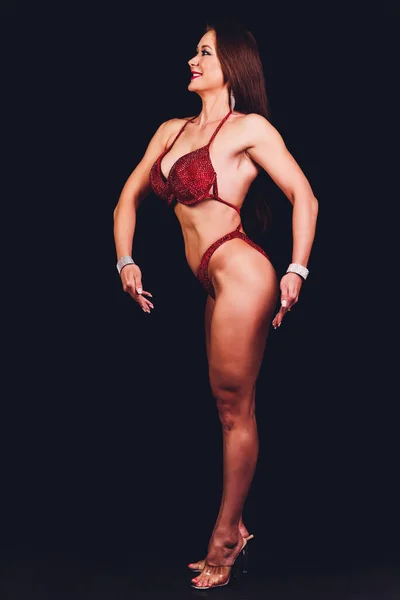 Morena modelo fitness femenino con cuerpo perfecto posando sobre fondo negro . — Foto de Stock