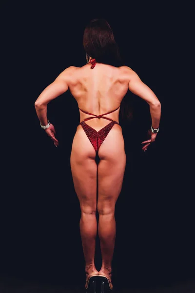 黑发女子健身模特，身材完美，背景为黑色. — 图库照片