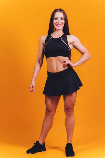 Brunetka žena fitness model s perfektní tělo pózovat na pozadí. — Stock fotografie