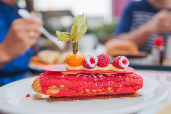 Delicioso eclair framboesa rosa em uma placa branca — Fotografia de Stock