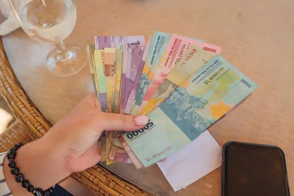 Mano sosteniendo el dinero en la rupia indonesia después de obtener THR Tunjangan Hari Raya que es Eid Mubarak Bonos para los musulmanes empleado . — Foto de Stock