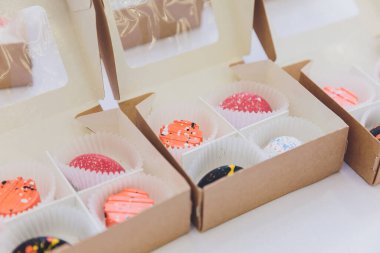 Cupcake paketleme, teslimat kutusu, pembe ve beyaz krem, seçici odak, vanilyalı kek yakın çekim.