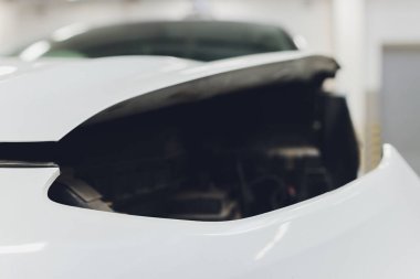 Otomatik serviste çalışan bir tamirci arabaya far takıyor. Araba farları tamir ediliyor. Otomatik servis yazıları için arkaplan resmi.