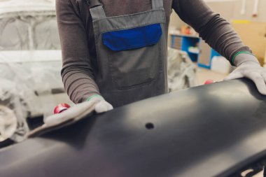 Otomatik tamirci güç tampon makinesi ile cilasını uygulayarak arabayı boya işi için hazırlıyor